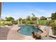 A backyard pool with rock features, desert landscaping, a waterfall, and a nearby grassy area at 4297 S Marion Pl, Chandler, AZ 85249