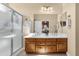 Bathroom with dual sinks, wooden cabinets, a large mirror, and a glass enclosed shower at 4483 E Sourwood Dr, Gilbert, AZ 85298