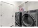 Bright laundry room featuring a set of front loading gray washer and dryer and overhead storage shelves at 4483 E Sourwood Dr, Gilbert, AZ 85298