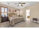 Relaxing main bedroom featuring plantation shutters, a ceiling fan, and views into the ensuite bathroom at 4483 E Sourwood Dr, Gilbert, AZ 85298