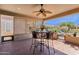 This covered patio features an overhead fan, tiled floors, and an adjacent view of the well-maintained backyard at 4483 E Sourwood Dr, Gilbert, AZ 85298