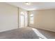 Bedroom with neutral walls, carpet flooring, and a doorway with arched window above at 5125 W Wikieup Ln, Glendale, AZ 85308