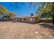 Wide angle of backyard highlighting a covered patio and house, with a dirt yard at 516 E Mesquite Ave, Apache Junction, AZ 85119