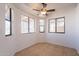 Bedroom with tile flooring, white walls, a ceiling fan, and ample natural light at 516 E Mesquite Ave, Apache Junction, AZ 85119