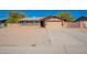 Tan single-story home with desert landscaping and an attached two-car garage at 516 E Mesquite Ave, Apache Junction, AZ 85119