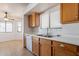 Bright kitchen featuring wooden cabinets, sink, and a view into the dining room at 516 E Mesquite Ave, Apache Junction, AZ 85119