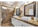 Bathroom featuring double sinks, decorative mirrors, and a large, tiled walk-in shower at 5165 S Peach Willow Ln, Gilbert, AZ 85298