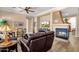 Living room with wood-look floors, neutral paint, a fireplace, and views of the golf course at 5165 S Peach Willow Ln, Gilbert, AZ 85298