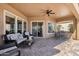 Inviting covered patio features a ceiling fan, brick pavers and comfortable seating area, perfect for outdoor relaxation at 5165 S Peach Willow Ln, Gilbert, AZ 85298