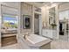 Bathroom with a soaking tub, dual vanities, and a view through an opening to the bedroom at 5421 E Juniper Canyon Dr, Cave Creek, AZ 85331