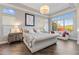 Spacious bedroom with a tufted bed, tray ceiling, a chandelier, and a sitting area by the large window at 5421 E Juniper Canyon Dr, Cave Creek, AZ 85331