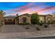 Front exterior shot showcasing a well-manicured lawn, a stone-accented facade and a wide driveway at 5421 E Juniper Canyon Dr, Cave Creek, AZ 85331