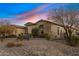 Exterior shot featuring a desert-landscaped home, accentuated by a beautiful sunset at 5421 E Juniper Canyon Dr, Cave Creek, AZ 85331