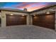 Spacious two-car garage featuring custom wood doors and a paved driveway against a colorful sunset at 5421 E Juniper Canyon Dr, Cave Creek, AZ 85331