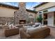 Inviting outdoor living space with a stone fireplace, comfortable seating, and stylish decor for relaxation at 5421 E Juniper Canyon Dr, Cave Creek, AZ 85331