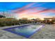 Stunning swimming pool with fountains surrounded by lounge chairs for ultimate relaxation at sunset at 5421 E Juniper Canyon Dr, Cave Creek, AZ 85331