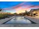 Beautiful backyard features a refreshing swimming pool with fountains under a picturesque sunset sky at 5421 E Juniper Canyon Dr, Cave Creek, AZ 85331