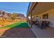 Spacious backyard featuring a putting green, patio seating, and mountain views at 5556 E Singletree St, Apache Junction, AZ 85119