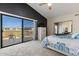 Bright main bedroom featuring a balcony, ceiling fan, dark accent wall, and mirrored closet at 5556 E Singletree St, Apache Junction, AZ 85119