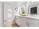 Bright bathroom with double vanity, white cabinetry, sleek mirrors, and designer accents for a modern feel at 6012 E Vernon Ave, Scottsdale, AZ 85257