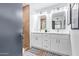 Bathroom featuring double sink, white cabinets, sleek hardware and modern lighting fixtures, providing a functional and stylish space at 6012 E Vernon Ave, Scottsdale, AZ 85257