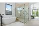 Modern bathroom featuring a soaking tub, glass shower enclosure, and a window at 6313 N 10Th Dr, Phoenix, AZ 85013