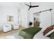 Bright main bedroom featuring a ceiling fan and a barn door that leads to a bathroom at 6313 N 10Th Dr, Phoenix, AZ 85013