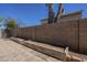 A block fence surrounds planter beds and a tiled ground in the backyard at 6841 W Yucca St, Peoria, AZ 85345