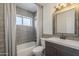 Well-lit bathroom features a shower and bathtub combo with gray tiles and a wood-trimmed mirror at 6841 W Yucca St, Peoria, AZ 85345