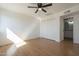 Cozy bedroom with laminate flooring and a fan, leading to an ensuite bathroom, and closet at 6841 W Yucca St, Peoria, AZ 85345