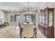 Elegant dining room with a chandelier, decorative cabinet, and travertine flooring at 7686 S Myrtle Ave, Tempe, AZ 85284