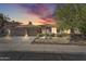 Charming home exterior showcasing a well-manicured front yard and attached three-car garage, enhanced by a stunning sky at dusk at 7686 S Myrtle Ave, Tempe, AZ 85284