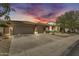 Charming home exterior showcasing a well-manicured front yard and attached three-car garage, enhanced by a stunning sky at dusk at 7686 S Myrtle Ave, Tempe, AZ 85284