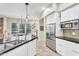 Well-lit kitchen with stainless steel appliances, white cabinets, and black countertops at 7686 S Myrtle Ave, Tempe, AZ 85284