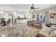 Open-concept living room with a kitchen island, travertine floors, and ample seating at 7686 S Myrtle Ave, Tempe, AZ 85284