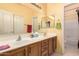 Bathroom with a dual sink vanity, framed mirror, and neutral color scheme at 7703 E Sayan St, Mesa, AZ 85207