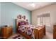 Cozy bedroom with colorful accents, ceiling fan, and lots of natural light at 7703 E Sayan St, Mesa, AZ 85207