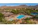 Aerial view of a stunning community pool and tennis courts with mature landscaping in a desert setting at 7703 E Sayan St, Mesa, AZ 85207