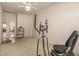 Open exercise room featuring a stationary bike, shelving, and neutral tones at 7703 E Sayan St, Mesa, AZ 85207