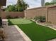 A well-maintained backyard with a beautiful putting green surrounded by lush greenery and desert landscaping at 9196 E Evans Dr, Scottsdale, AZ 85260