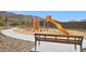 Fun community playground featuring slides, climbing structures, and a comfortable bench for relaxation and supervision at 9831 S 11Th St, Phoenix, AZ 85042