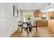 Bright dining area with a round glass table, dark wood chairs, and a view to the kitchen and access to the backyard at 10422 N 11Th Pl # 3, Phoenix, AZ 85020