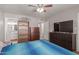 Comfortable bedroom featuring a ceiling fan, a large TV, and an attached bathroom at 113 N Ridge Cir, Mesa, AZ 85203