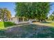 Exterior view of a home featuring a lush backyard with fruit trees at 14006 N Tumblebrook Way, Sun City, AZ 85351