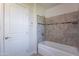 Tiled bathtub and shower with decorative accent stripe at 14006 N Tumblebrook Way, Sun City, AZ 85351