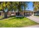 Traditional single-story home featuring mature shade trees and a covered carport at 14006 N Tumblebrook Way, Sun City, AZ 85351