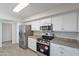 This kitchen features stainless steel appliances, granite countertops, and white cabinets at 14006 N Tumblebrook Way, Sun City, AZ 85351