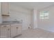 Laundry room with a utility sink, storage cabinets, and a window at 14006 N Tumblebrook Way, Sun City, AZ 85351