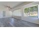 Enclosed sun room with grey wood-look floors, ceiling fan, and bright natural light at 14006 N Tumblebrook Way, Sun City, AZ 85351