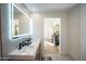 Bright bathroom with double vanity, lighted mirror, modern fixtures, and view to a nearby bedroom at 15440 N 54Th St, Scottsdale, AZ 85254